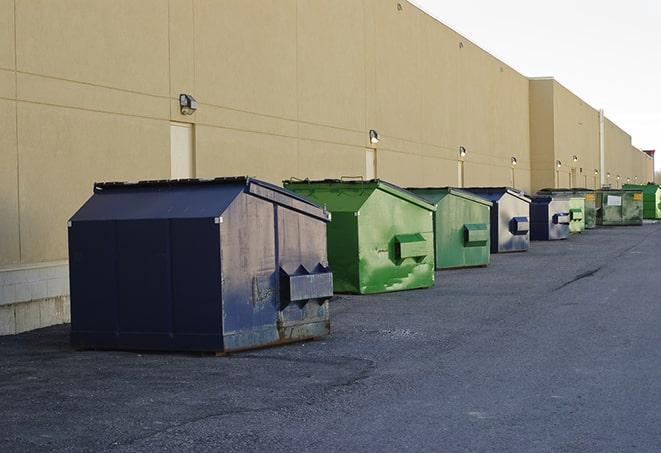 a row of yellow and blue dumpsters at a construction site in Arcadia